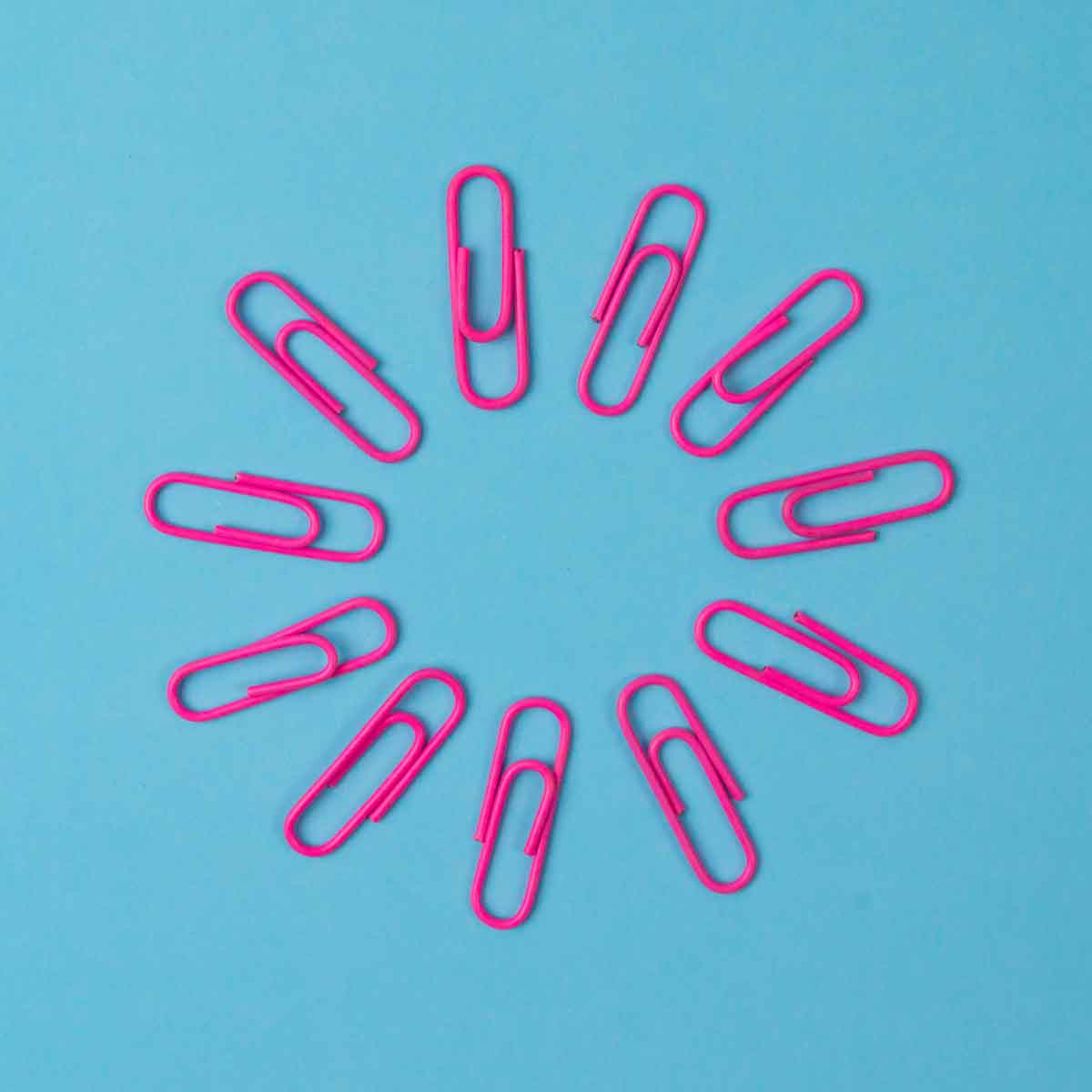 Magenta paperclips in a circle on a blue background