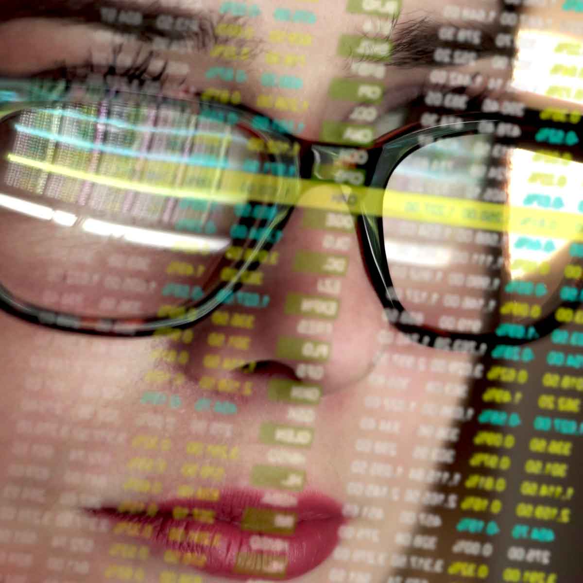 Close up of woman's reflection on computer screen full of financial information